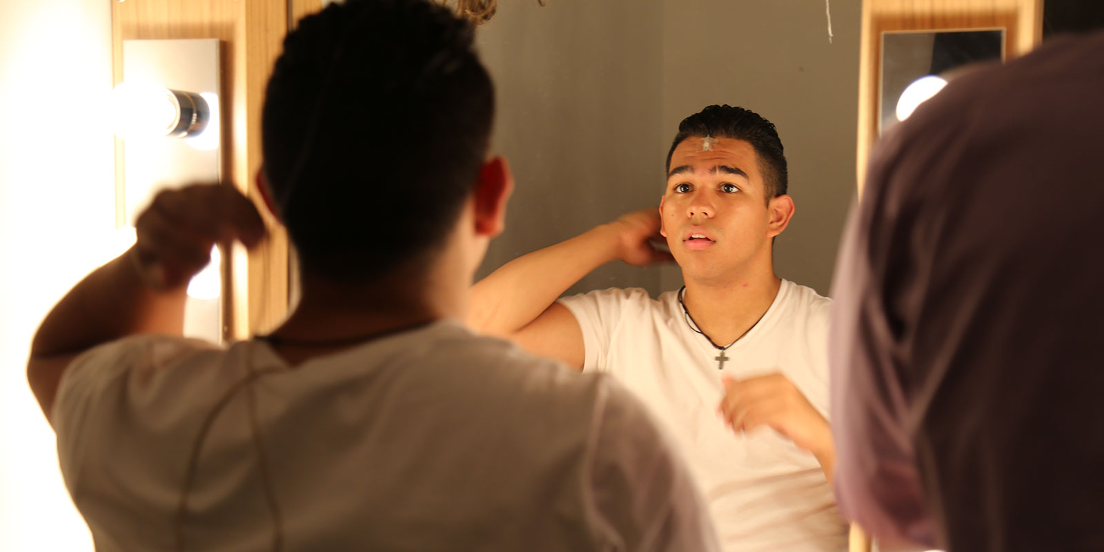 male student looking in a mirror
