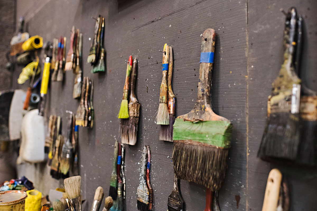 paint brushes hanging on a wall
